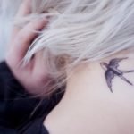 Black Flying Swallow Tattoo On Girl Back Neck
