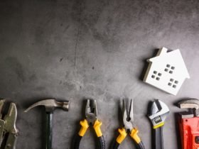 Wooden house and construction tools on stone pattern background with copy space.Home Repair concept, Repair maintenance concept, Renovation concept.